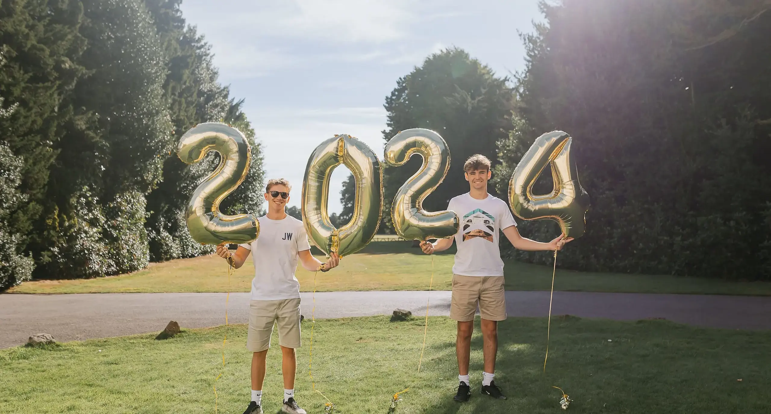 Students holding up four balloons which read '2024'