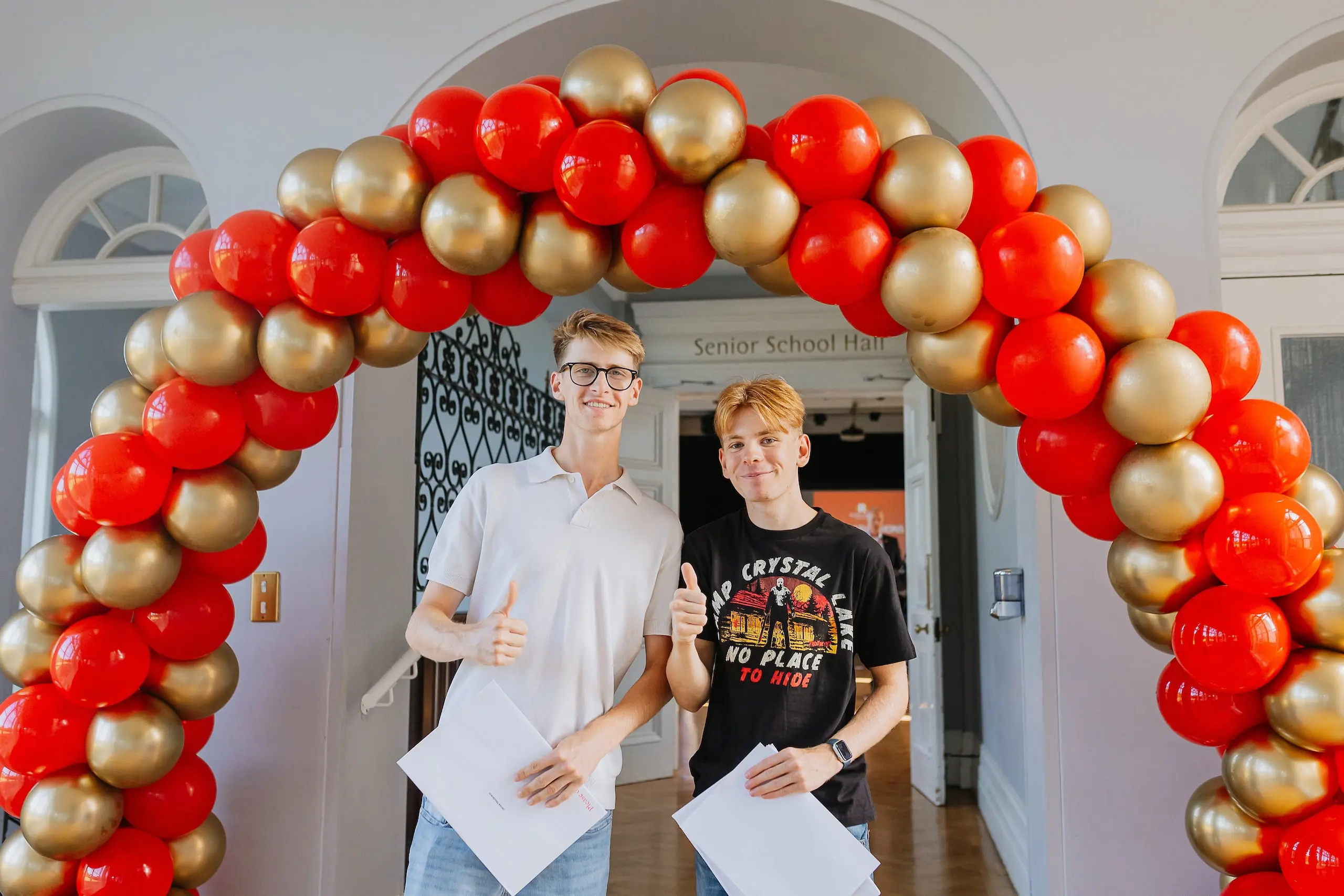 Students standing under a balloon arch