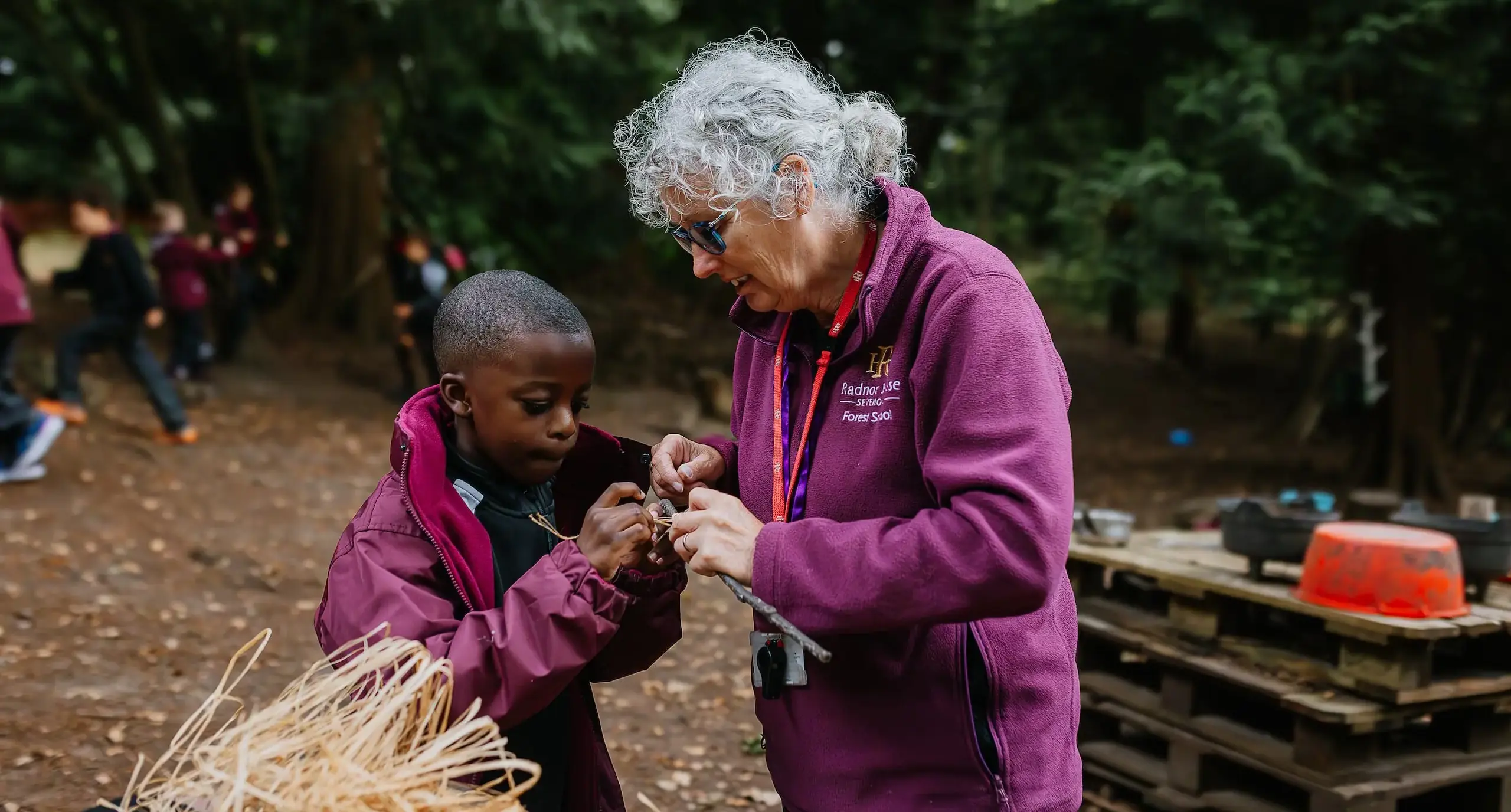 Student and teacher wrapping straw around a stick