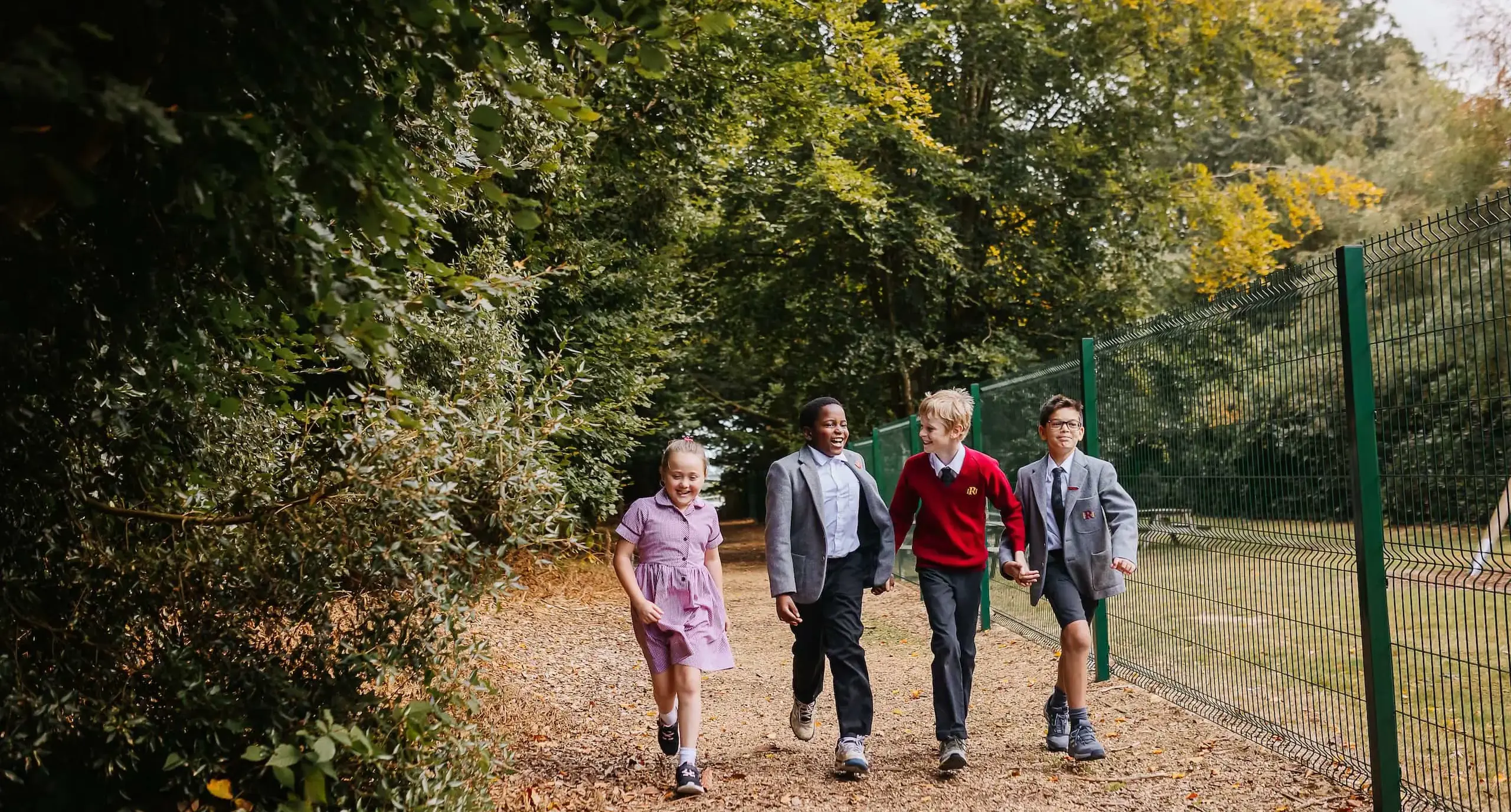 Children walking together on a bark path