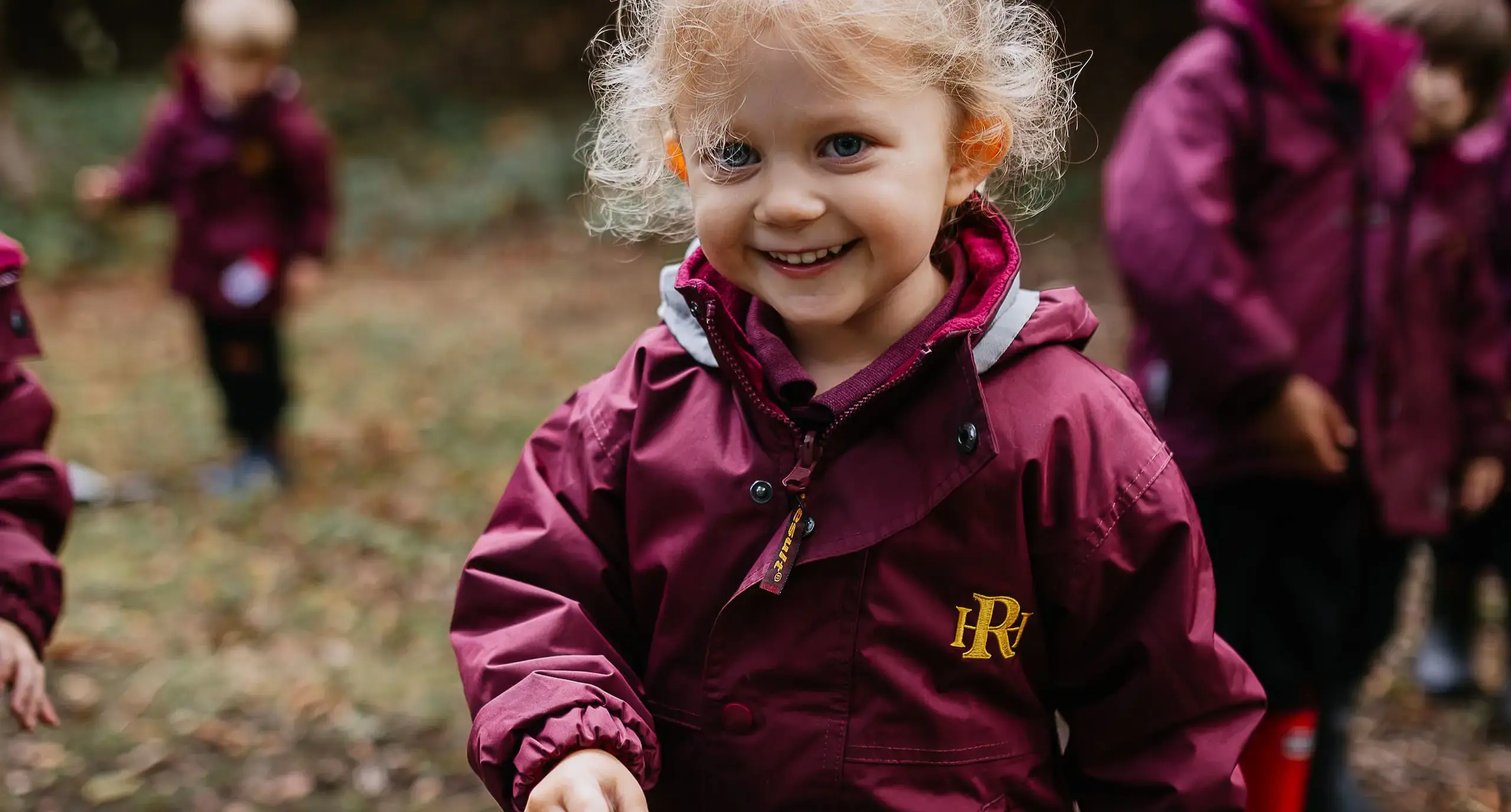 Rador student wearing a raincoat, smiling