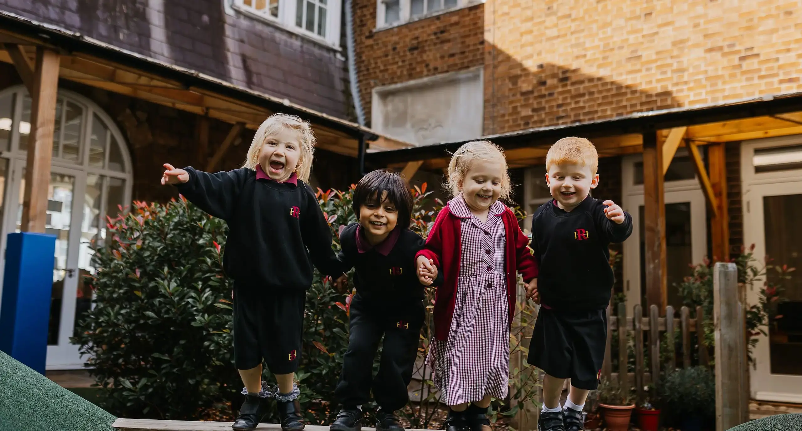 Prep students standing hand in hand on playground equipment