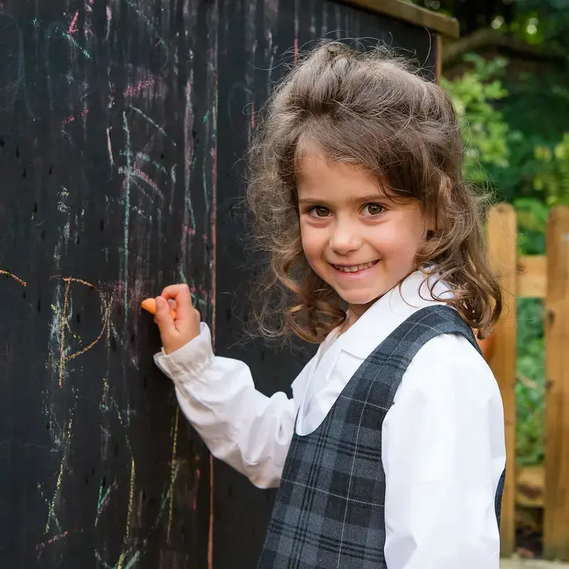 Pre-prep pupil playing with chalk in the playground