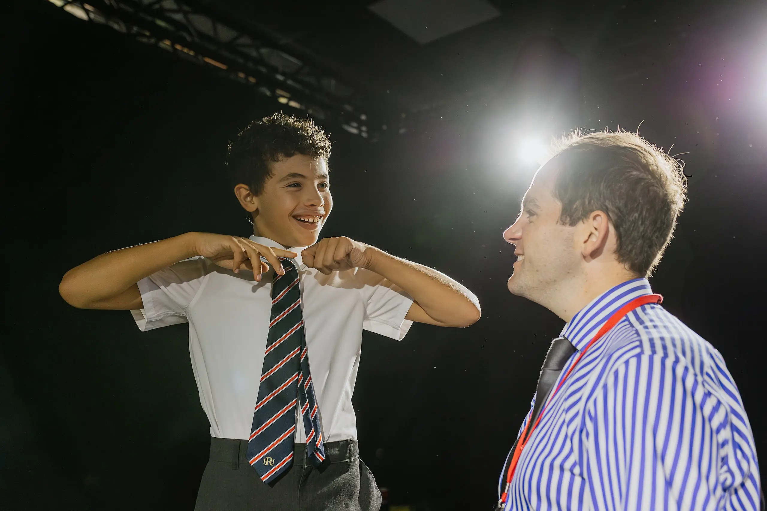 Drama teacher smiling up at student