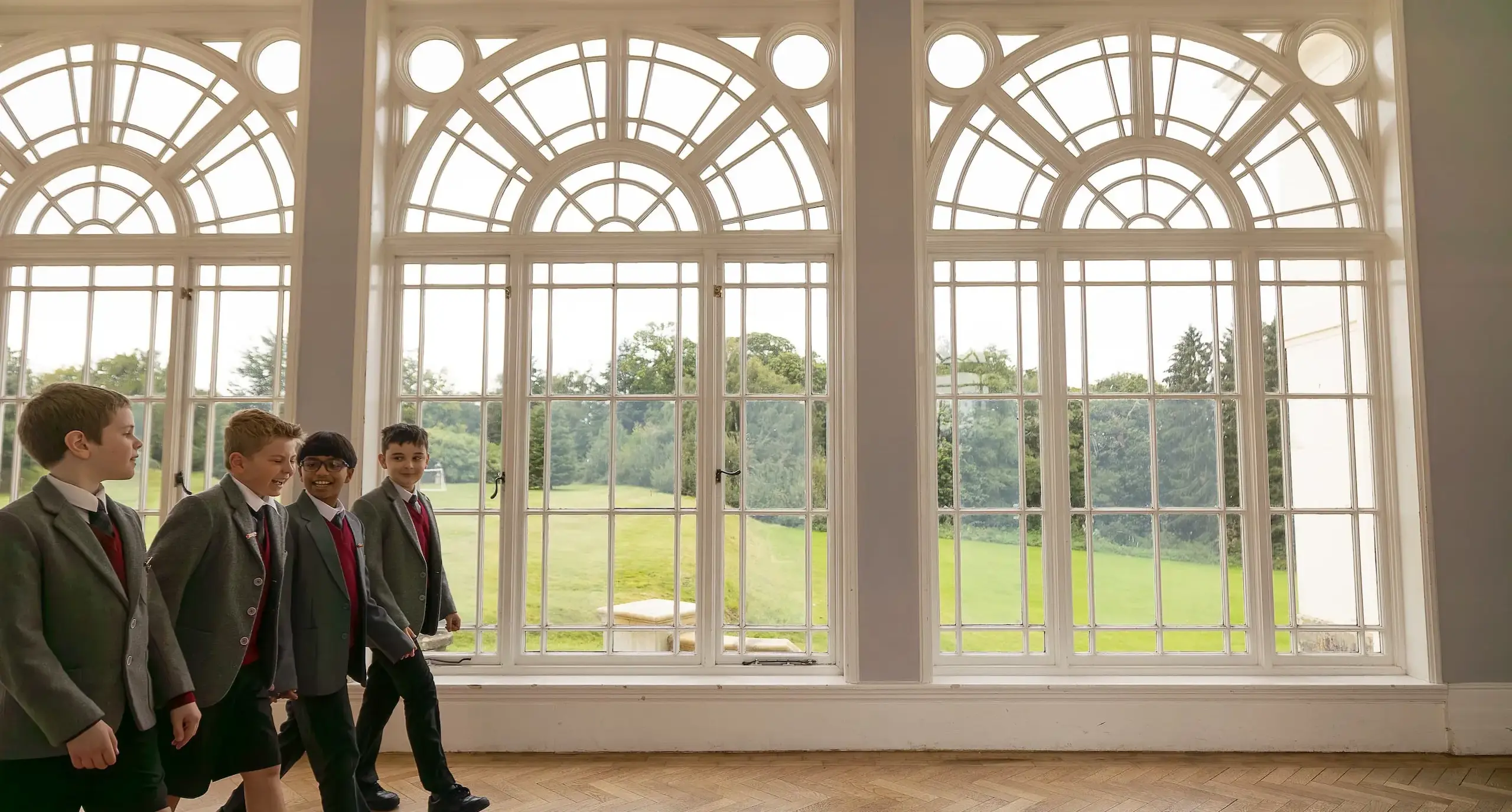 Students walking through a windowed corridor