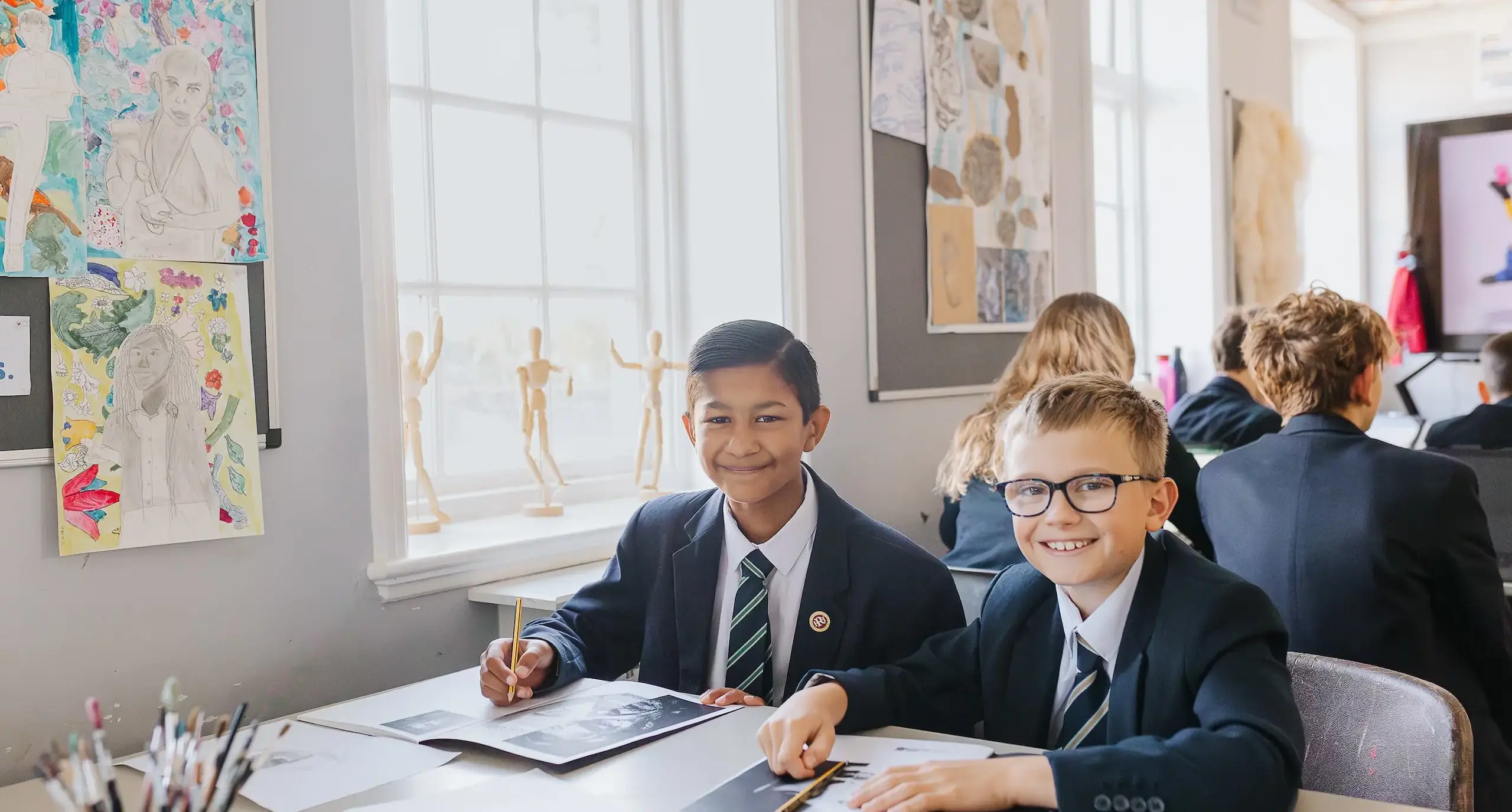 Students smile up from their schoolwork